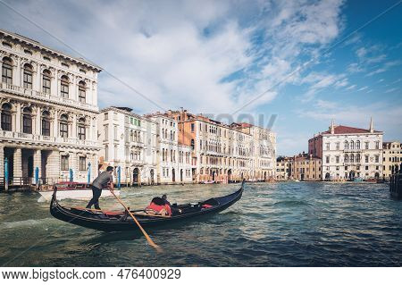 Venetian Gondolier Punting Gondola Through Grand Canal Of Venice, Italy. Gondola Is A Traditional, F