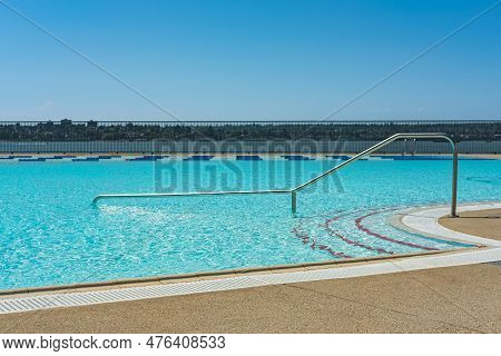 Swimming Pool. Blue Spa Swimming Pool With Clean Water. Railing Stairs Down To The Pool With Entranc