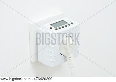 Computer- Timer Plugged In An Outlet. Electric Plug Computer Regulating Usage Of Electricity, Turns 