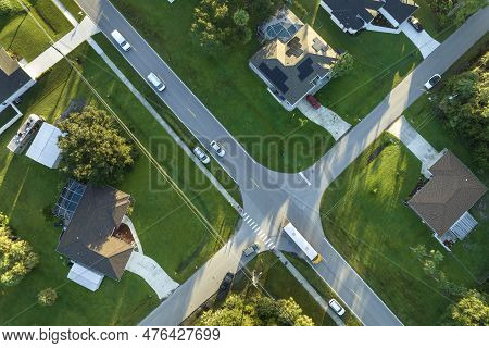 Aerial View Of American Yellow School Bus Picking Up Children At Sidewalk Bus Stop For Their Lessong