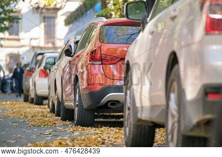 City Traffic With Many Cars Parked In Line On Street Side.