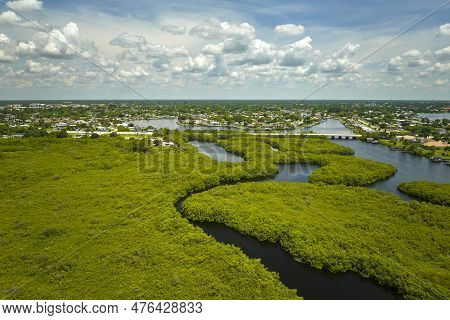 Overhead View Of Everglades Swamp With Green Vegetation Between Water Inlets And Rural Private House