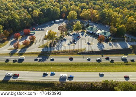 Top View Of Large Rest Area Near Busy Multilane American Freeway With Fast Moving Cars And Trucks. R