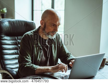Man Deeply Concentrated On Work As Freelancer. With Unwavering Focus And Passion, He Immerses Himsel