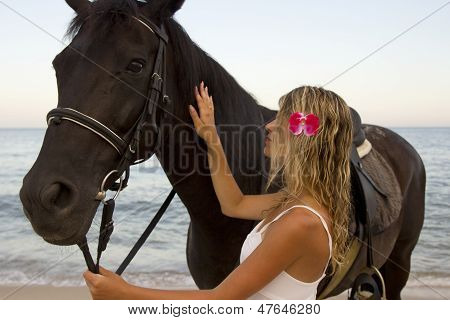 Pige med en hest ved havet