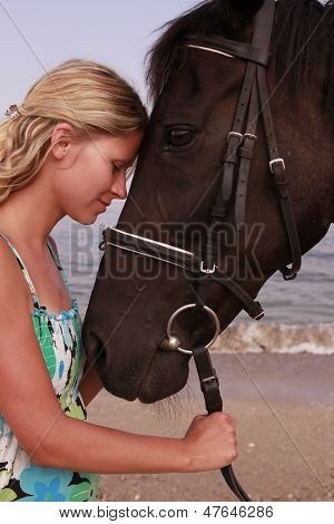Pige med en hest ved havet