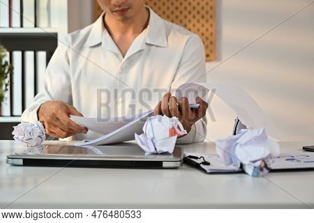Cropped Sot Of Male Entrepreneur Working With Account Documents At White Office Desk With Crumped Pa