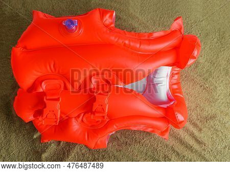 Childrens Inflatable Life Jacket Lies On The Sand.