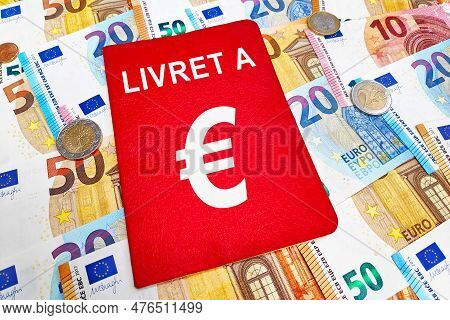 Livret A Atop Of A Stack Of Euro Banknotes And Coins. The Livret A Is A Historic Financial Product O