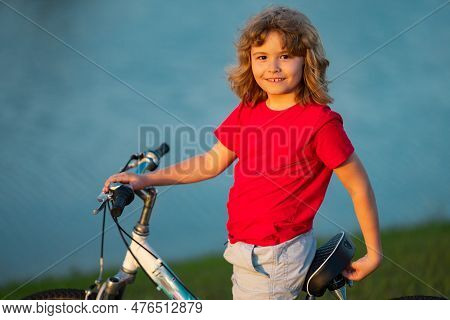 Little Kid Boy Ride A Bicycle In The Park. Kid Cycling On Bicycle. Happy Smiling Child Riding A Bike