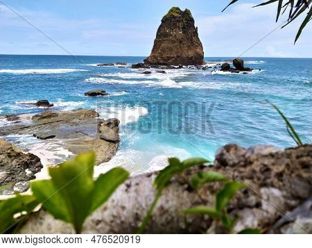 Blue Sea On Papuma Beach, Jember With Cliffs In The Middle Of The Sea