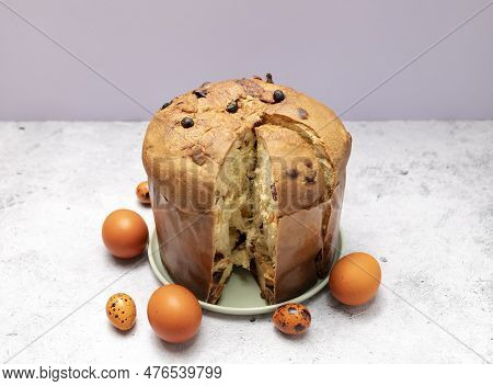 Easter Panettone Italian Cake On Table With Colored Easter Hen Eggs. Fruitcake, Sweet Bread, Origina