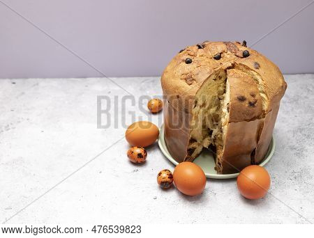 Easter Panettone Italian Cake On Table With Colored Easter Hen Eggs. Fruitcake, Sweet Bread, Origina