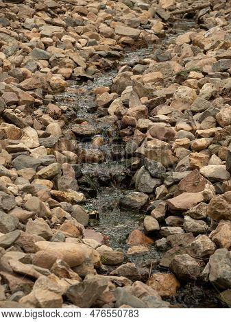 A Beautiful Small River Flows Over The Stones Forming Cascades. Water In A Small River Flows Over Mo
