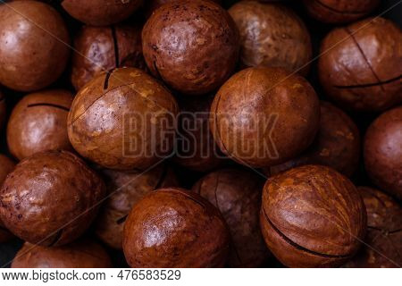 Delicious Roasted Macadamia Nuts In Shell On A Dark Textured Background