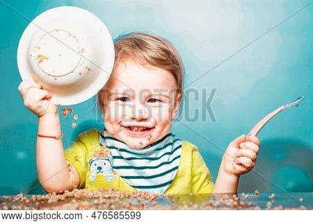 Cute Excited Funny Baby With Plate And Spoon, Babies Eating. Kid Boy Eating Healthy Food.