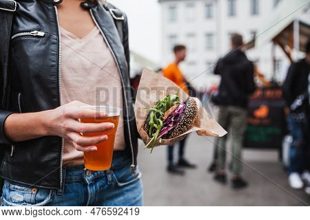 Close Up Of Woman Hands Holding Delicious Organic Salmon Vegetarian Burger And Homebrewed Ipa Beer O