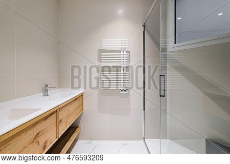 Modern Bathroom With Wooden Base For White Sinks. Radiator For Warm Water Procedures In Winter. Show