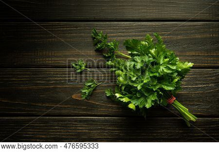 A Bunch Of Green Fresh Fragrant Parsley On A Dark Kitchen Table Before Adding To Food For Taste And 