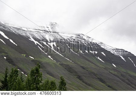 Holabyrda Hill Near Holar Town, Iceland Cover By Snow Cap And Clouds