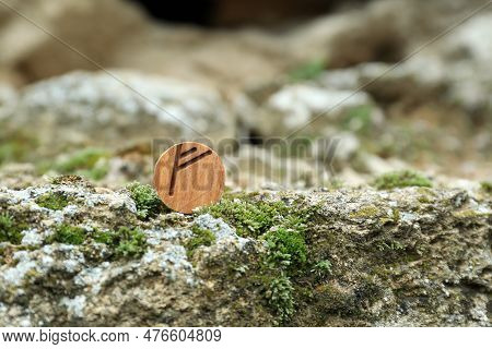 Wooden Rune Fehu On Stone With Moss Outdoors. Space For Text