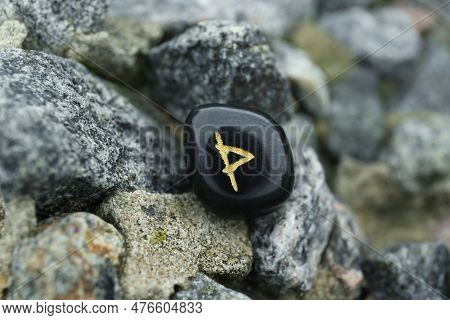 Black Rune Wunjo On Stones Outdoors, Closeup