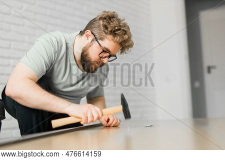 Young Attractive Man Assembles Furniture - Handwerker And Interior Objects Concept