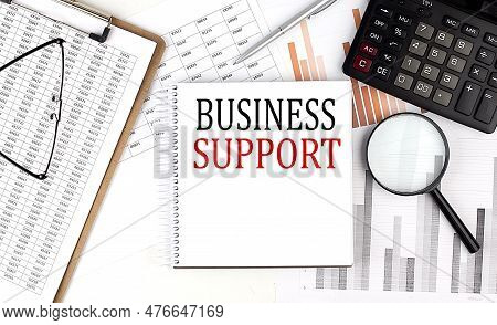 Business Support Text On Notebook With Clipboard And Calculator On Chart Background