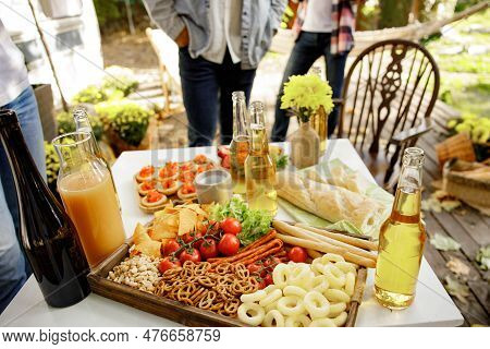 Delicious Picnic Food Is Served Outdoors On A Wooden Table, Consisting Of A Set Of Beer Snacks, Brus