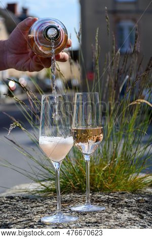 Pouring Of Premier Cru Sparkling Rose Wine With Bubbles Champagne With View On Old Houses Of Hautvil