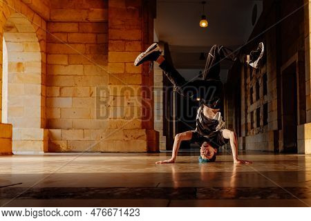 Young Teenage White Boy Dances Break Dance In The Old Streets Of A City. Modern Dance. B-boy. Hip Ho