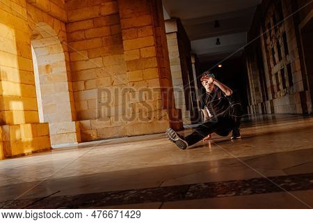 Young Teenage White Boy Dances Break Dance In The Old Streets Of A City. Modern Dance. B-boy. Hip Ho