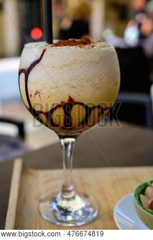 Glaass Of Iced Frappuccino Coffee With Whipped Cream, Chocolate And Ice Cubes