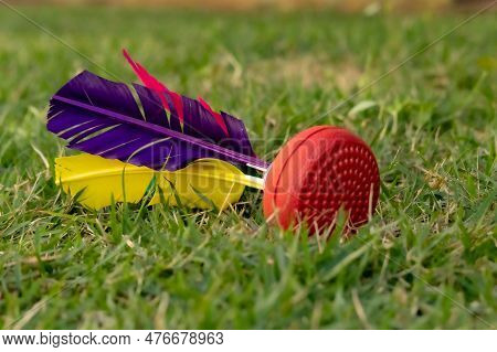Shuttlecock Toy With Colorful Feathers Falling On Green Grass