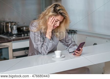 Sad Woman Drink Coffee And Using Phone At Home In Morning. Tired Female Madel Chatting Smartphone In