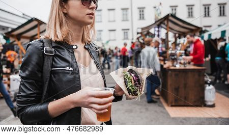 Close Up Of Woman Hands Holding Delicious Organic Salmon Vegetarian Burger And Homebrewed Ipa Beer O