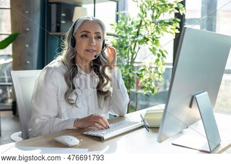 Good-looking Mature Business Woman At The Computrer Looking Busy