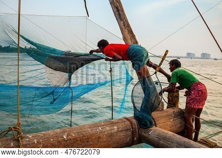 Cochin, India - March 13, 2012: Unidentified Fishermen And Chinese Fishing Nets In Fort Kochi In Coc