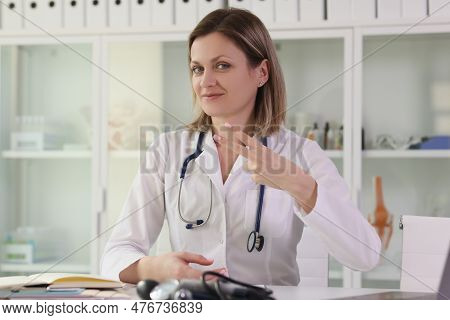 Positive Female Doctor Shows Two Finger Victory Gesture Looking In Camera And Smiling. Specialist In
