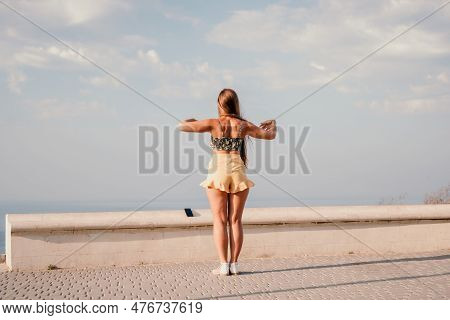 Woman Summer Dance. Silhouette Of A Happy Woman Who Dances, Spins And Raises Her Hands To The Sky. A
