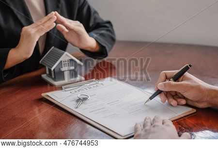 Hand A Real Estate Agent Hold The Home Model, And Explain The Business Contract, Rent, Buy, Mortgage
