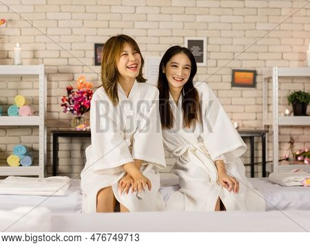 Two Asian Young Beautiful Happy Female Customers In White Clean Massaging Bathrobe Towel Sitting Res