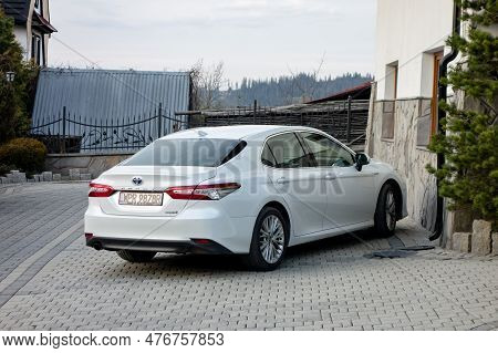 Murzasichle, Poland - April 28, 2023: Toyota Camry Hybrid White Sedan Parked In Front Of The Hotel R