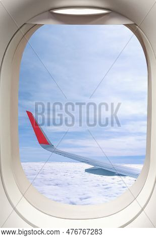 View From Inside Airplane Cabin Of Aircraft Wing While Flying Above Fluffy Clouds Inside Of Plane Wi