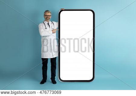 Handsome Middle Aged Doctor Showing Big Smartphone With White Screen