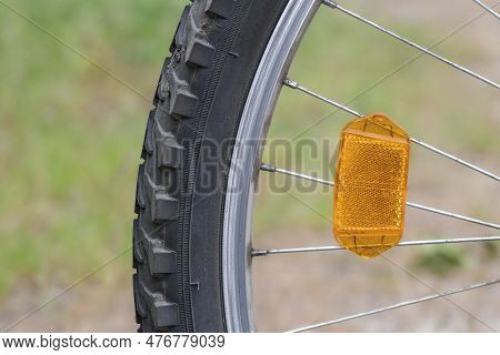 Orange Reflector On The Bicycle Wheel. Safety Device. Bike Wheel Reflector.