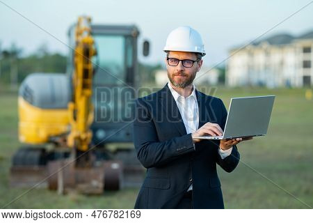 Construction Manager In Suit And Helmet At A Construction Site. Construction Manager Worker Or Super