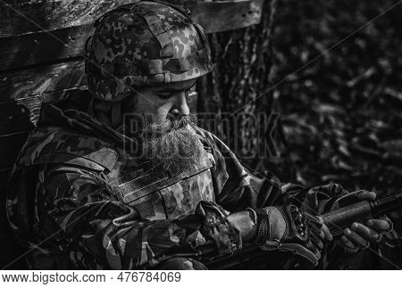 Tired Soldier. Army Soldier With Assault Rifle And Combat Helmet. Battle Of The Military In The War.