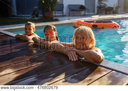 Active Aging And Intergenerational Relationships. Grandmother Gleefully Interacts With Grandchildren