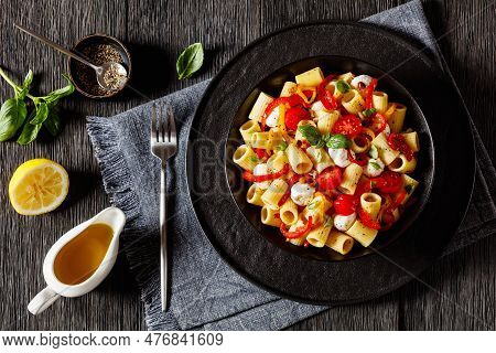 Roasted Pepper Tomato Mozzarella Pasta Salad In Black Bowl On Dark Oak Wood Table With Fork, Olive O